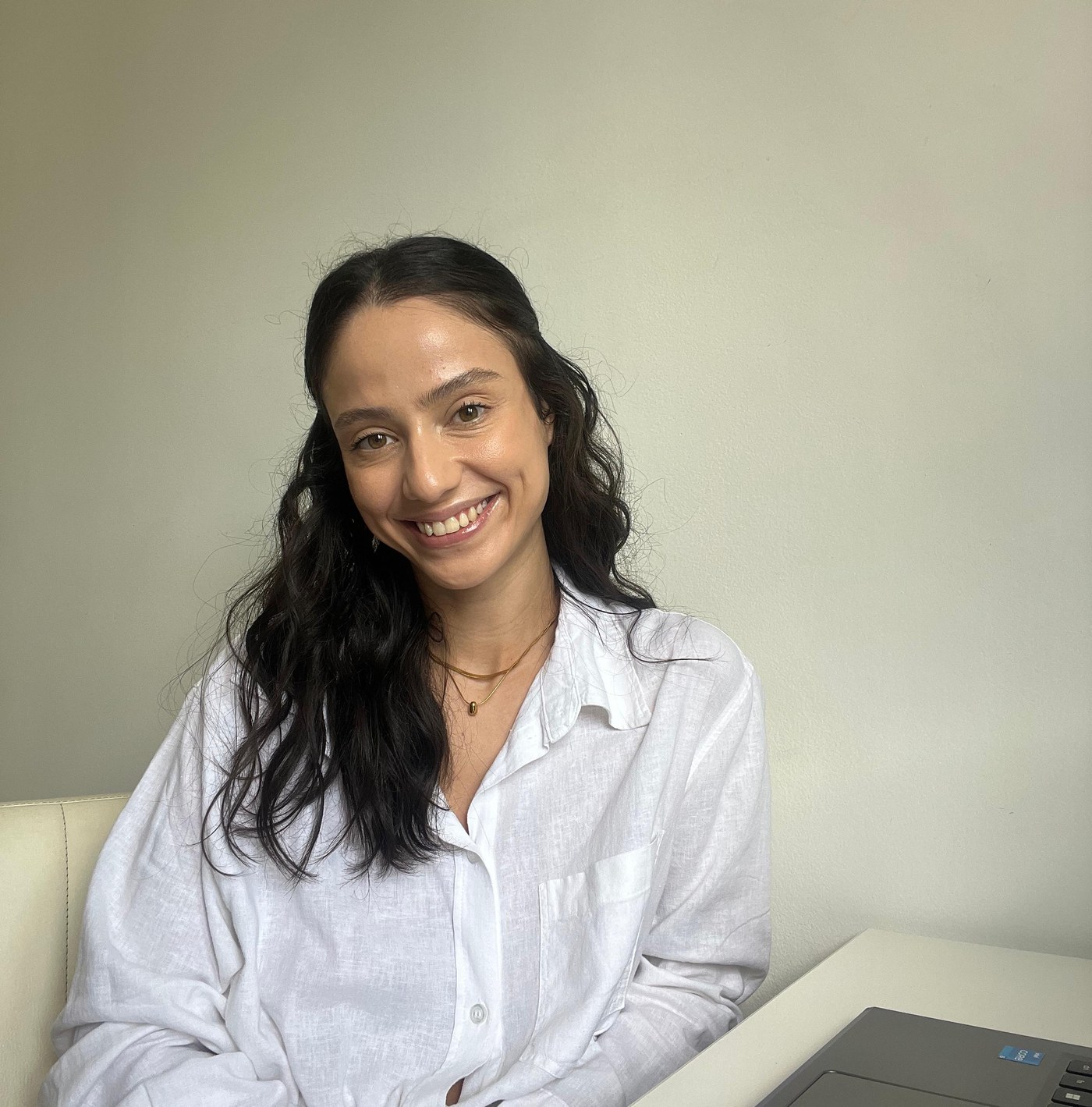 Mariana Amaral, psicóloga, sorrindo em ambiente acolhedor